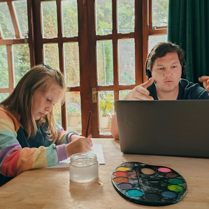 A parent and child sitting together at a laptop
